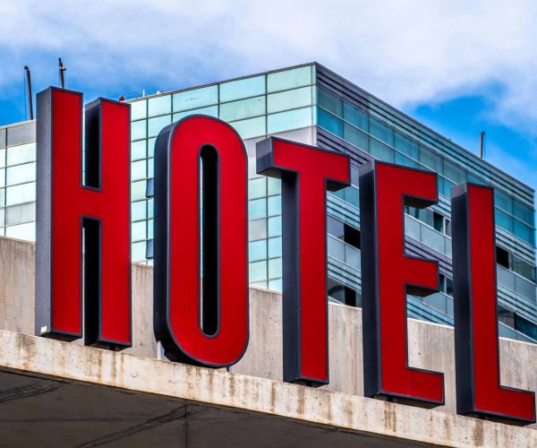 A close-up shot of signage of a hotel with red letters